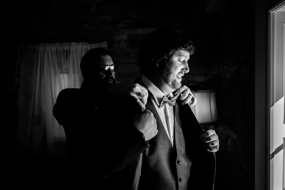 Wedding preparations captured in dramatic black and white lighting.