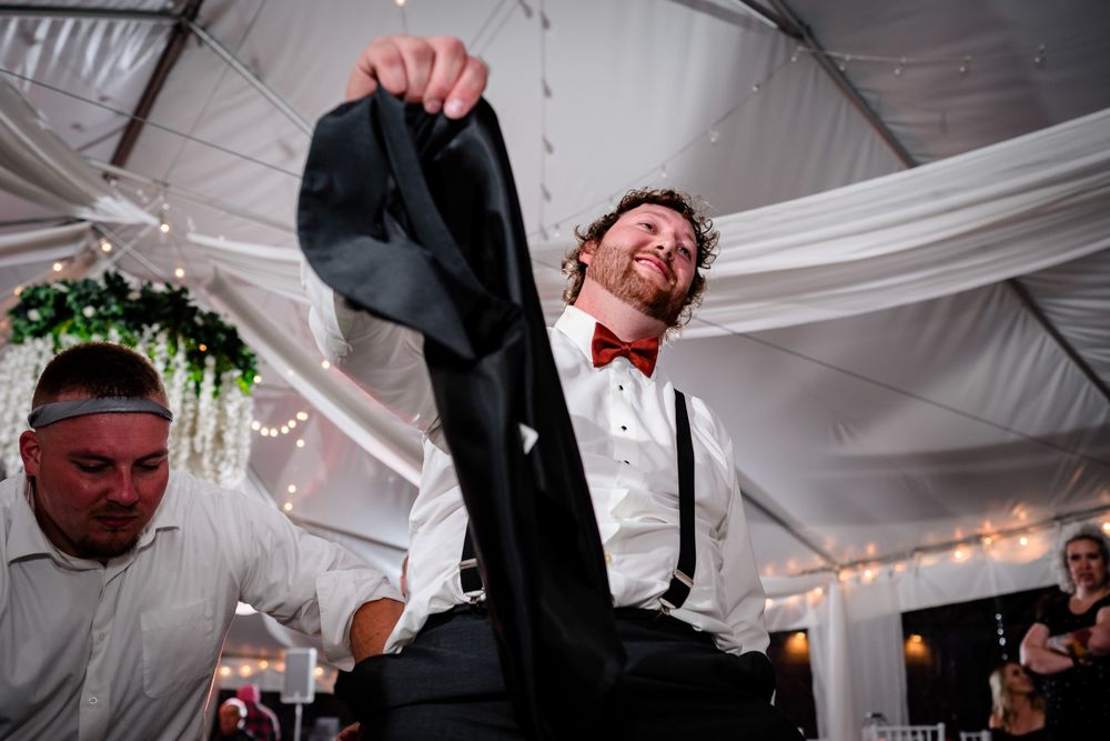 Wedding reception venue decorated with elegant white draping and hanging floral arrangements.
