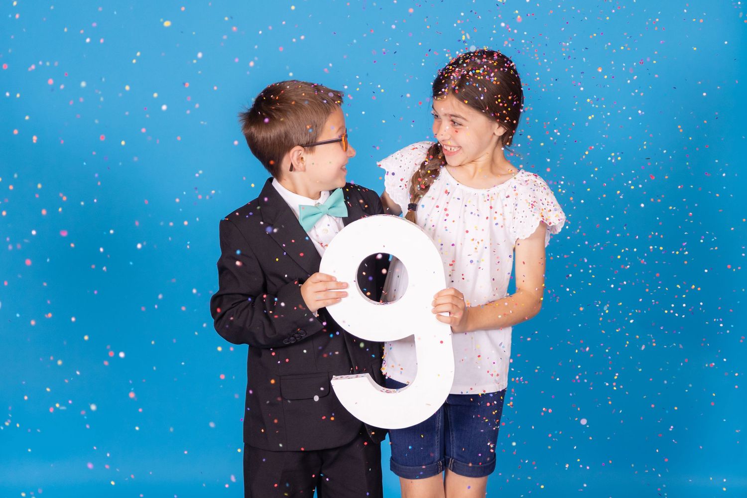 kids holding large 9 on savage blue jay backdrop with confetti in studio in clayton new jersey gloucester