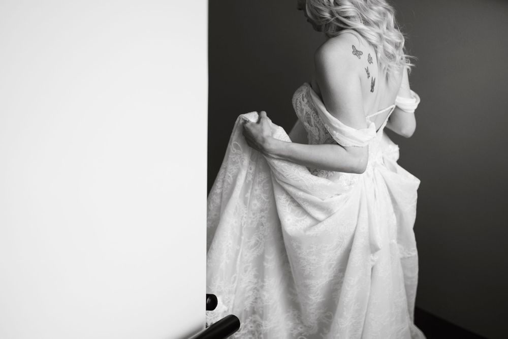 Artistic black and white portrait showing intricate details of a wedding dress.