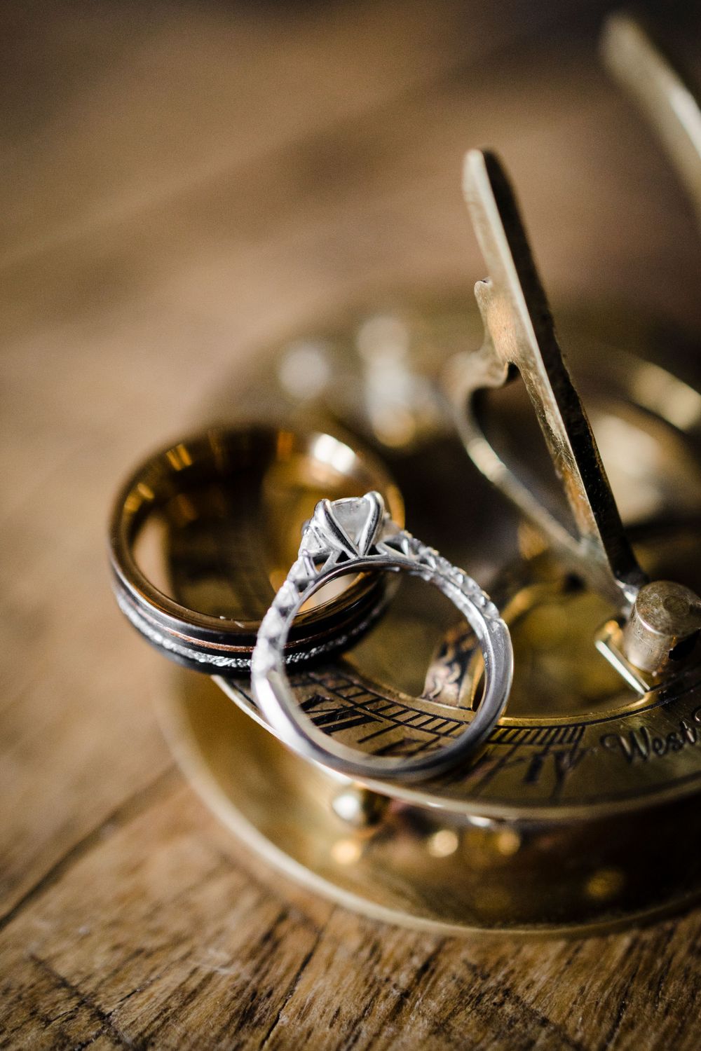 Wedding rings displayed on an antique brass sundial creating an artistic composition.