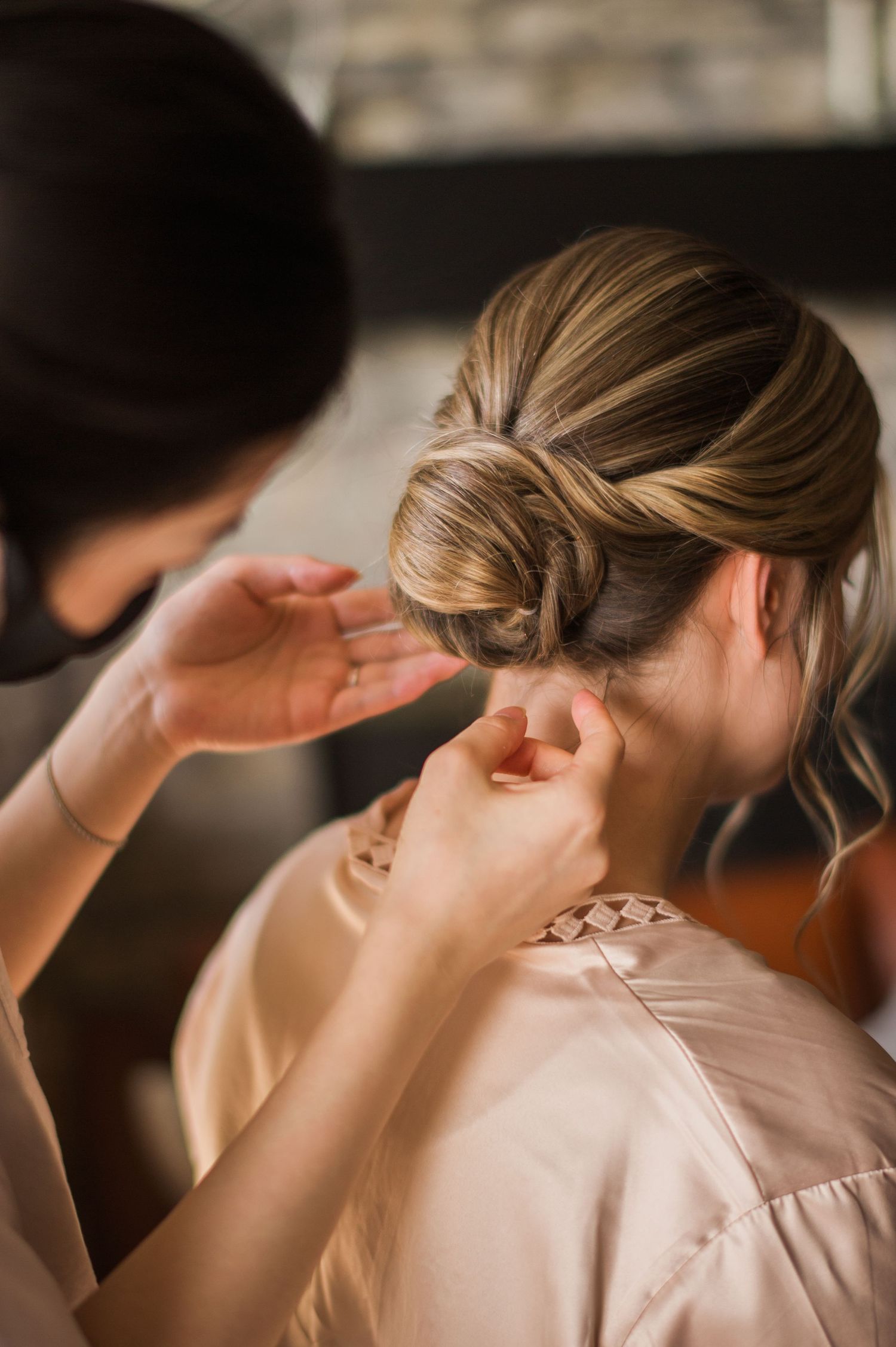 Elegant bridal hairstyling session showing intricate updo preparation.
