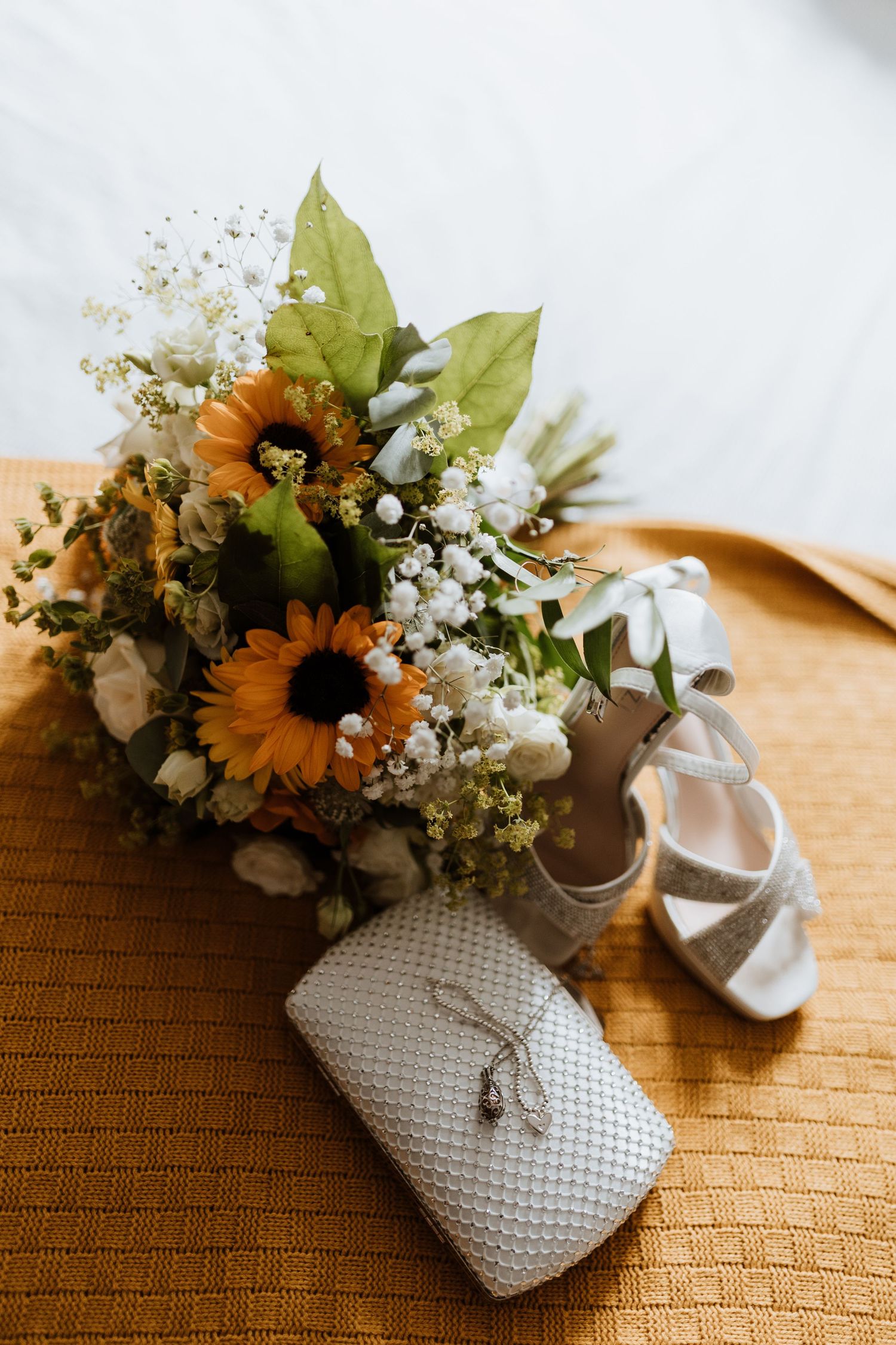 Beautiful detailed shot of sunflower bouquet and shoes and accessories.