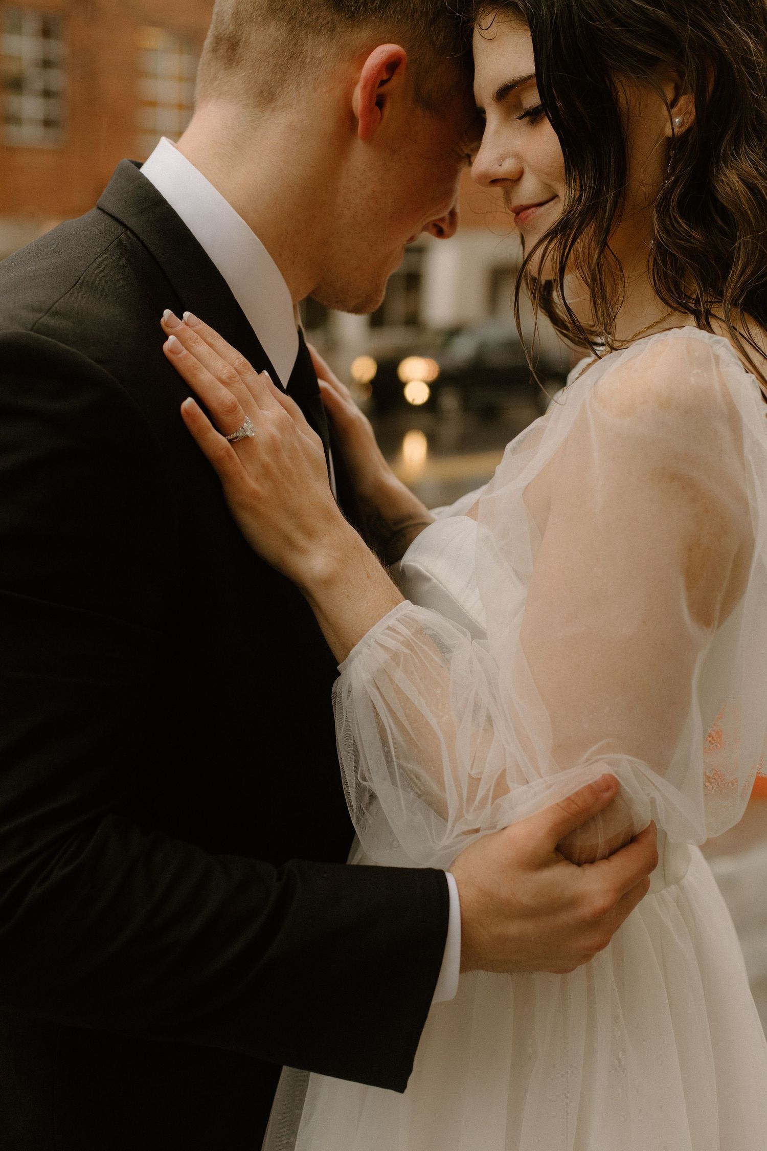 Romantic wedding portrait showing a tender intimate moment between newlyweds in warm lighting.