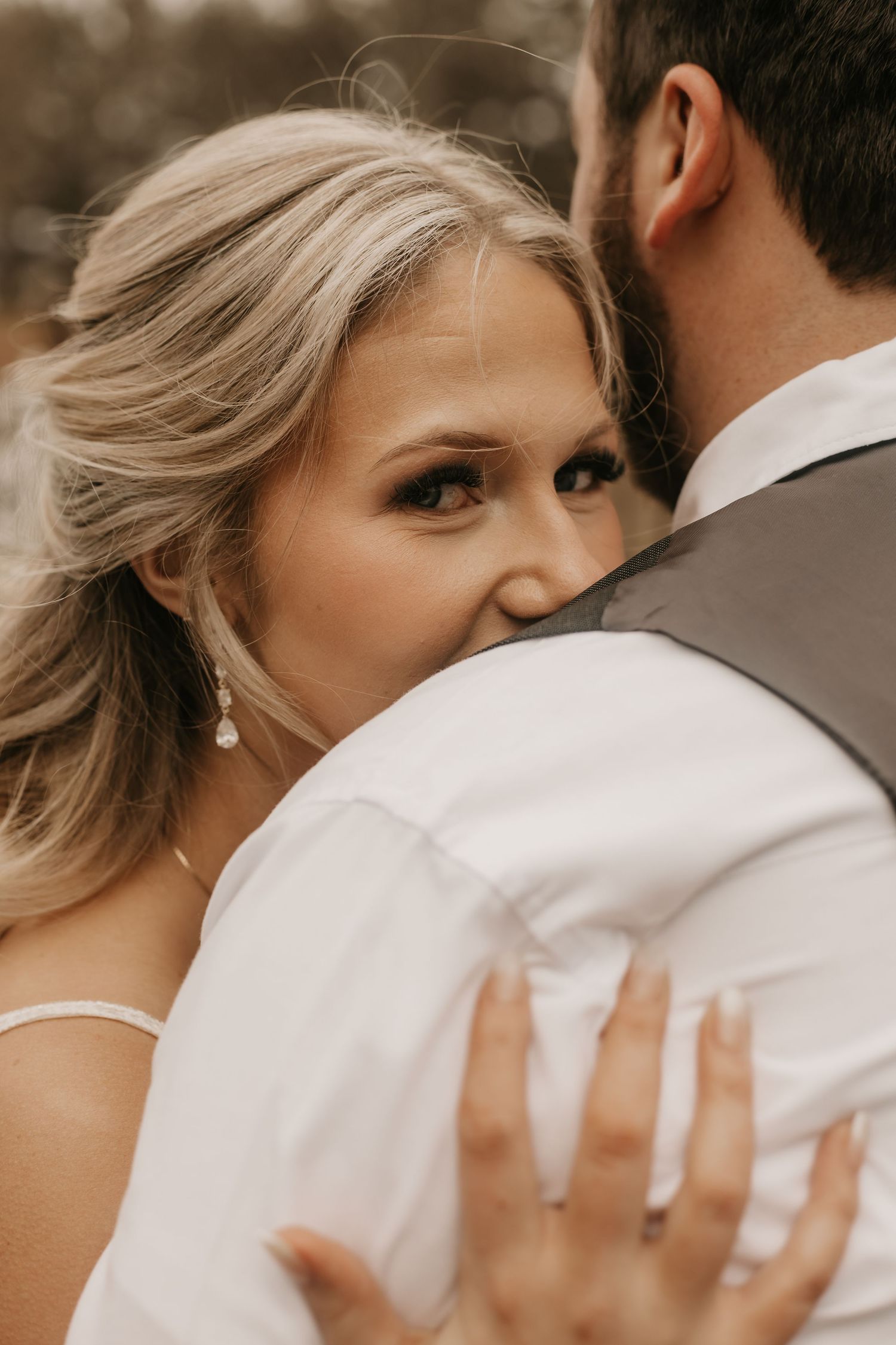Intimate wedding portrait showing closeup embrace against muted background.