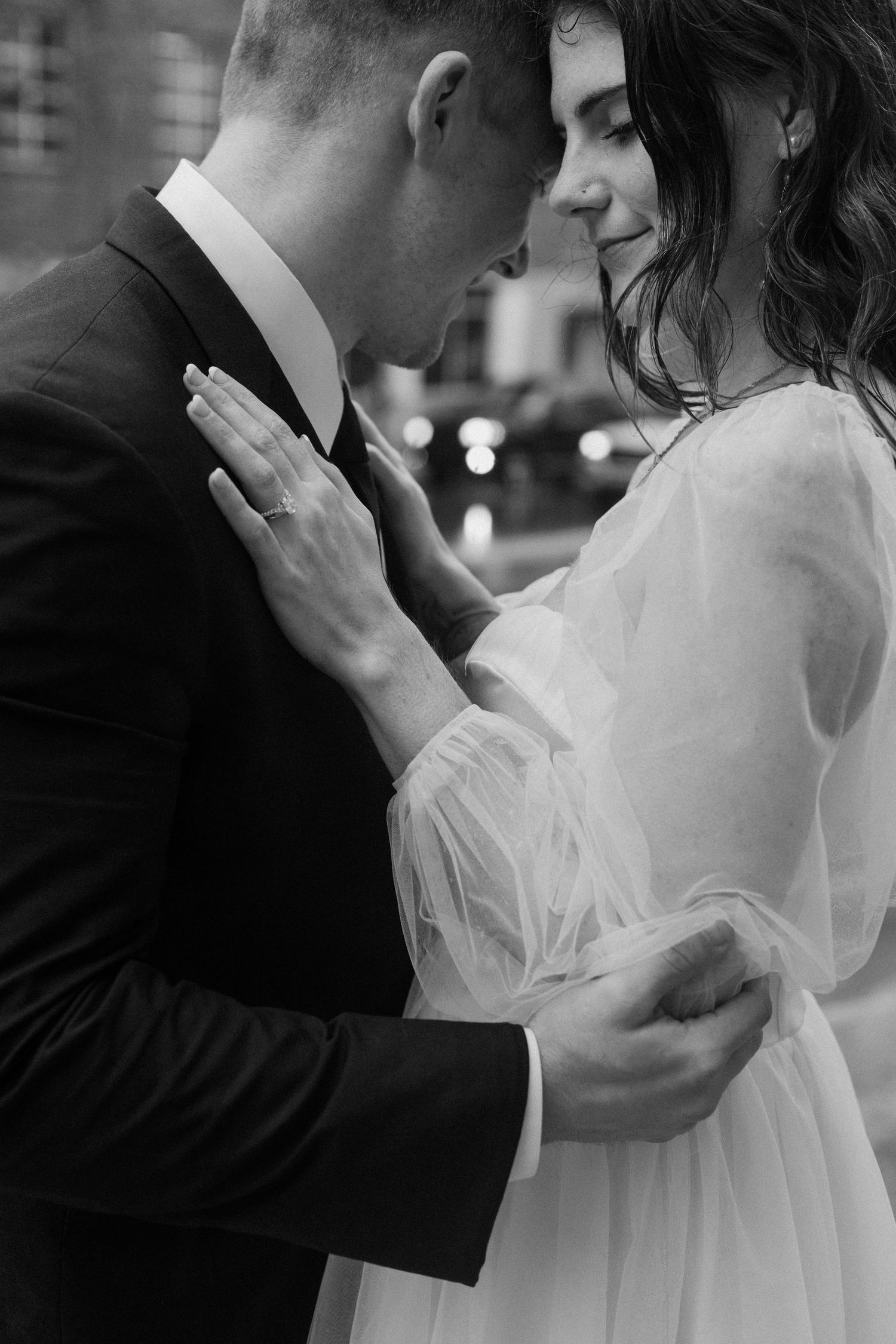 Black and white intimate portrait of a wedding couple sharing a tender moment.