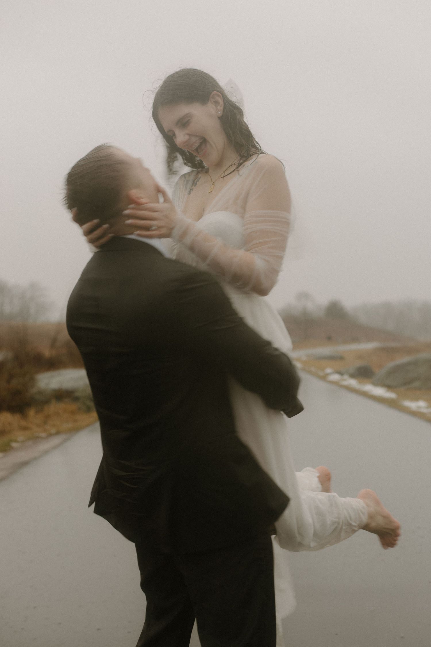 Intimate moment between newlyweds during a rainy day photoshoot.