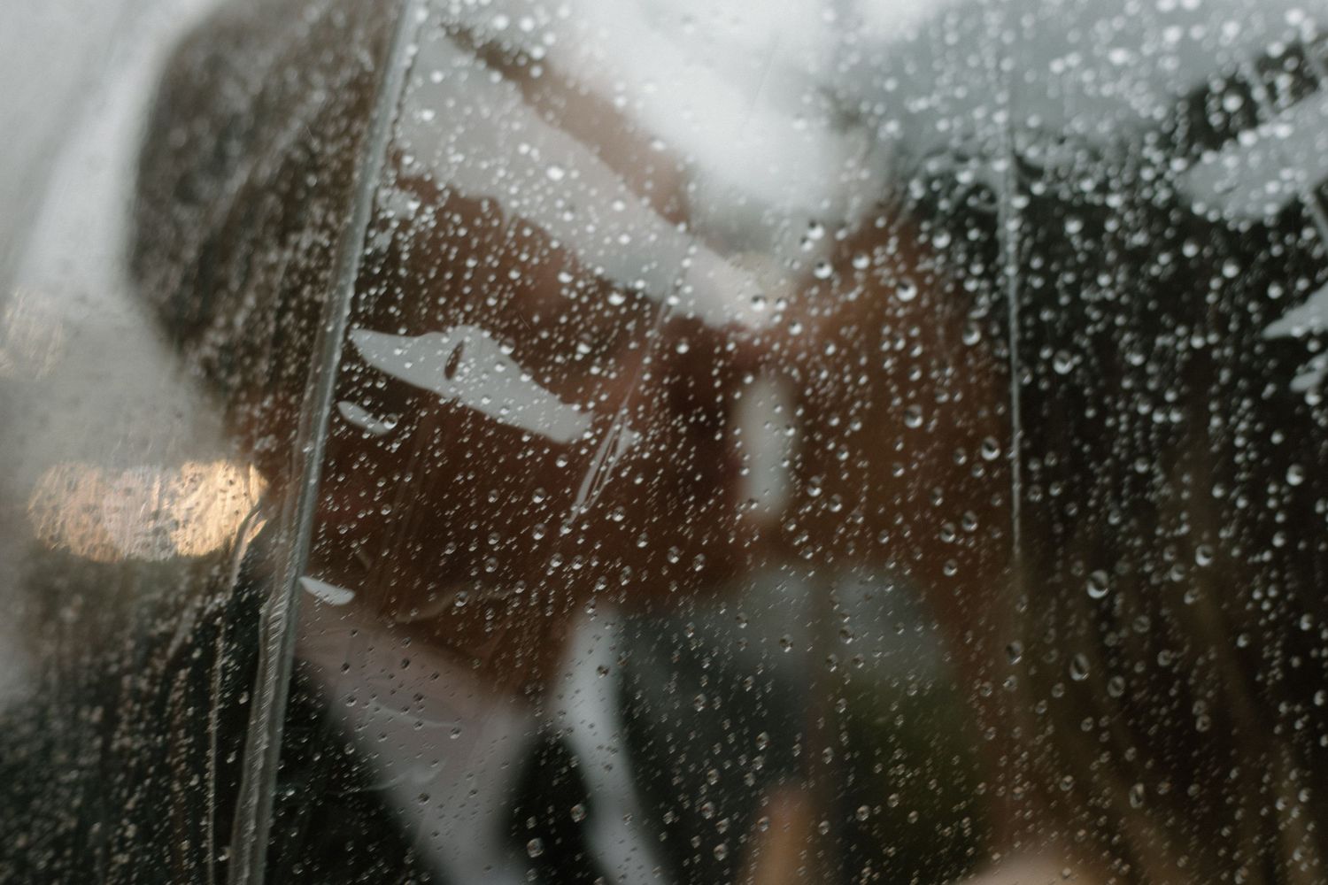Raindrops on a window create a dreamy, blurred effect on a rainy day.