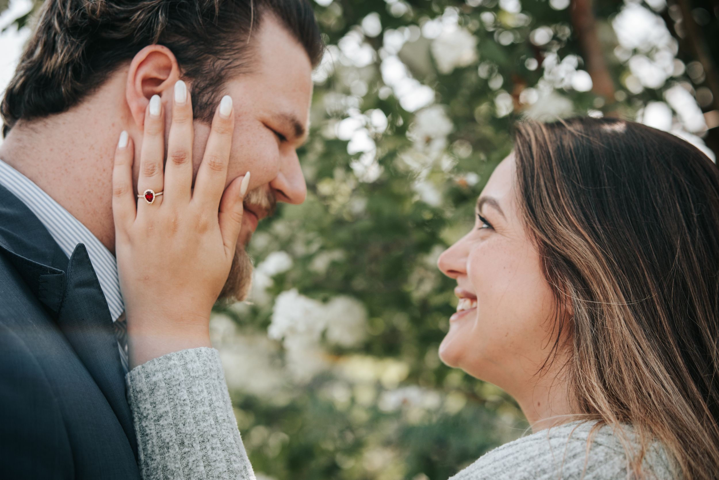 Intimate engagement moment captured with gentle touch and joyful expressions.