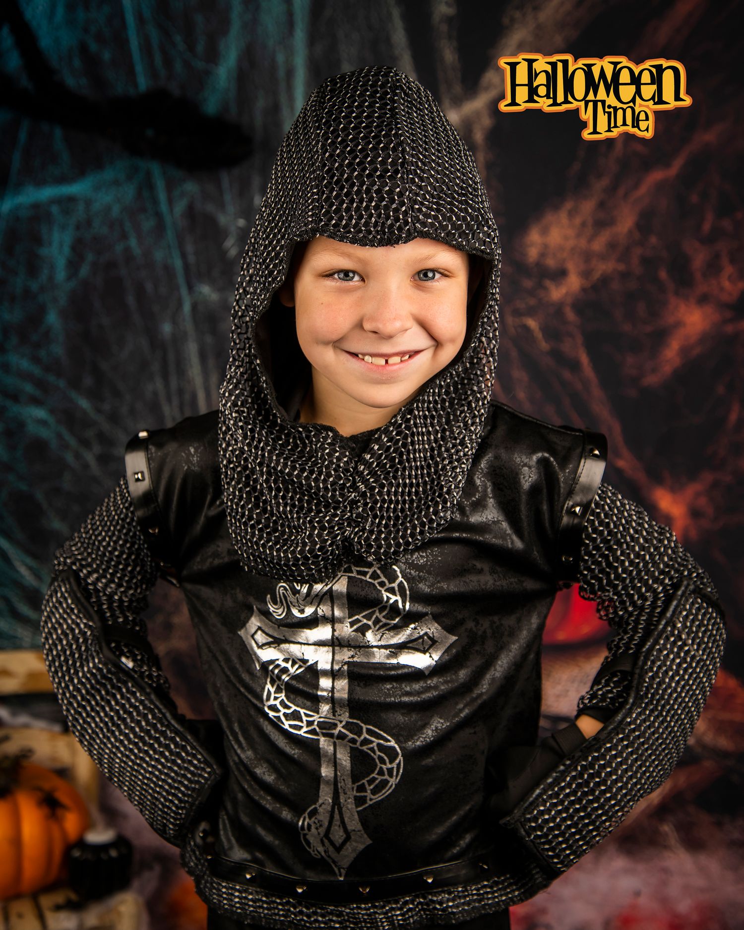 Medieval knight costume in chainmail and black armor against dark Halloween backdrop.
