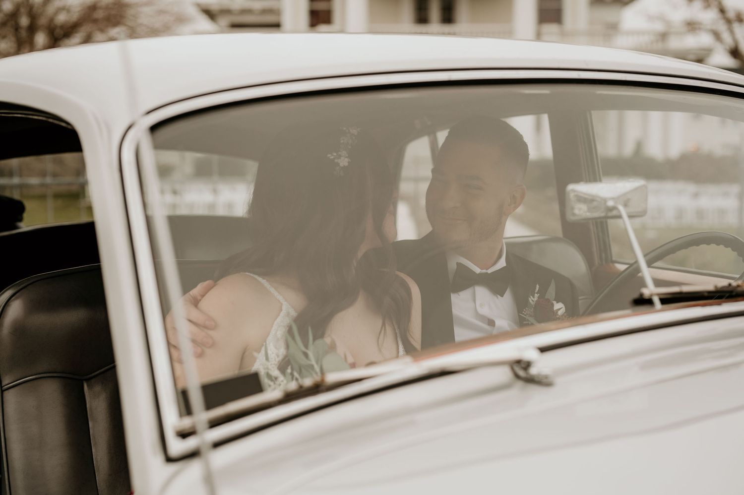 bride and groom sit together in old Rolls Royce