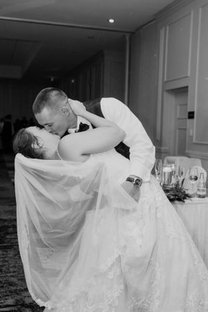 A romantic dip and kiss between newlyweds during their first dance.