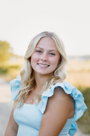 Portrait of person wearing blue ruffled dress in natural light.