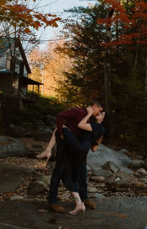 A romantic fall photoshoot showing a couple in an intimate embrace surrounded by autumn foliage.
