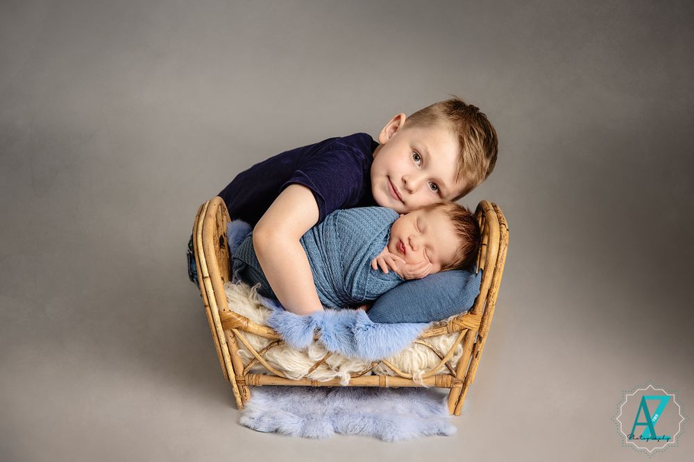 Wicker bassinet scene with blue cushioning against neutral studio background.