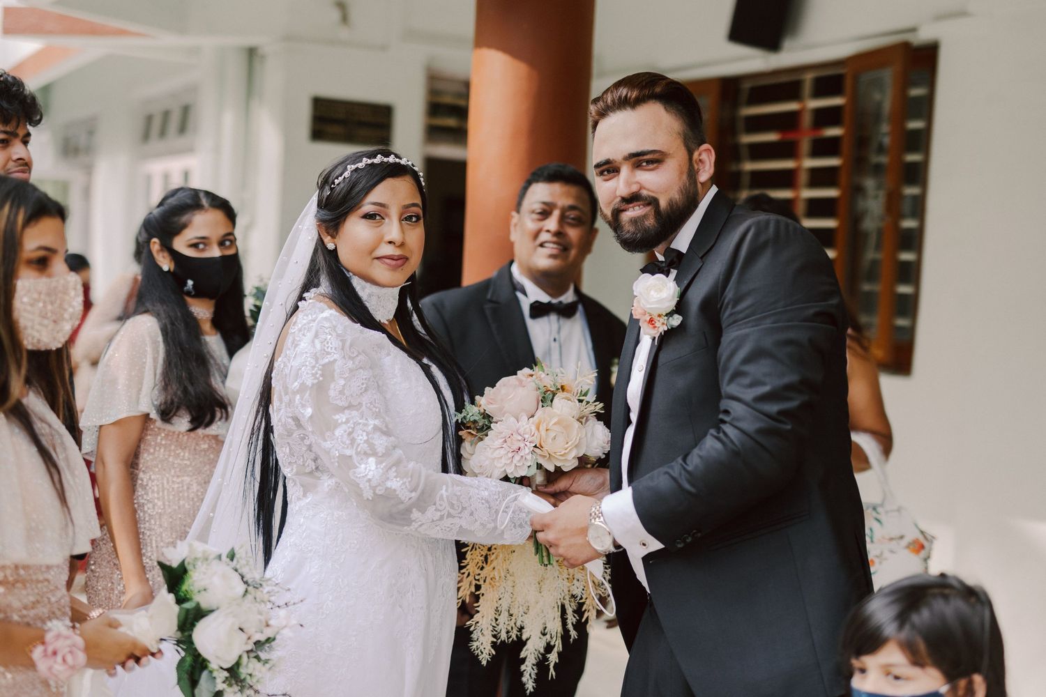Wedding ceremony taking place indoors with attendees in formal attire.