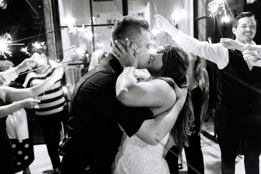 Black and white photo capturing an intimate moment between newlyweds during their reception celebration.