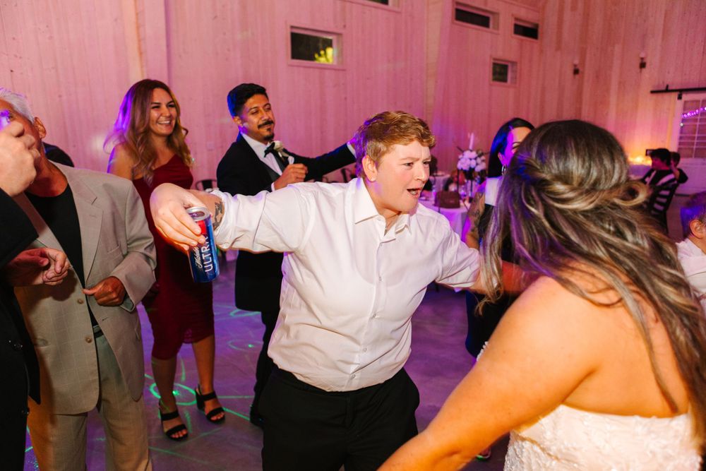 Wedding reception dance floor filled with guests enjoying lively celebration.
