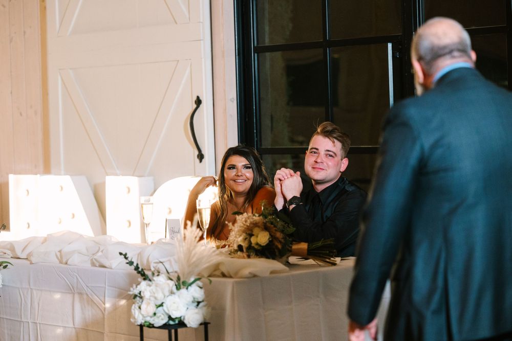 Wedding reception candid moment at head table with illuminated decor.
