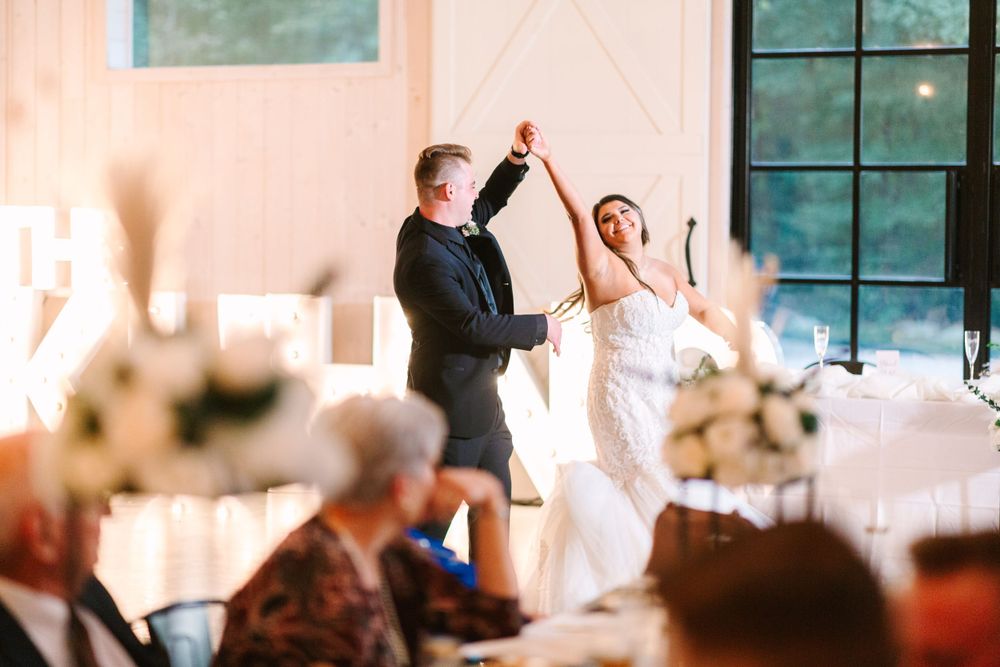 Wedding couple dancing and twirling during reception celebration.