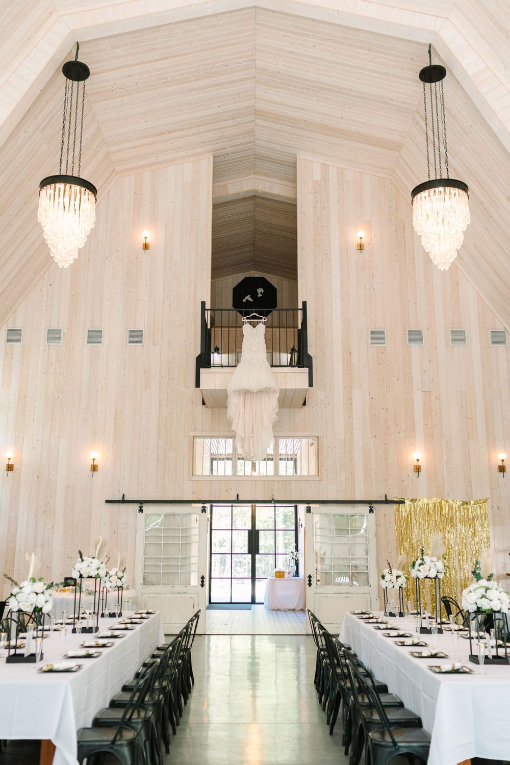 Elegant white chapel interior with crystal chandeliers and long reception tables.