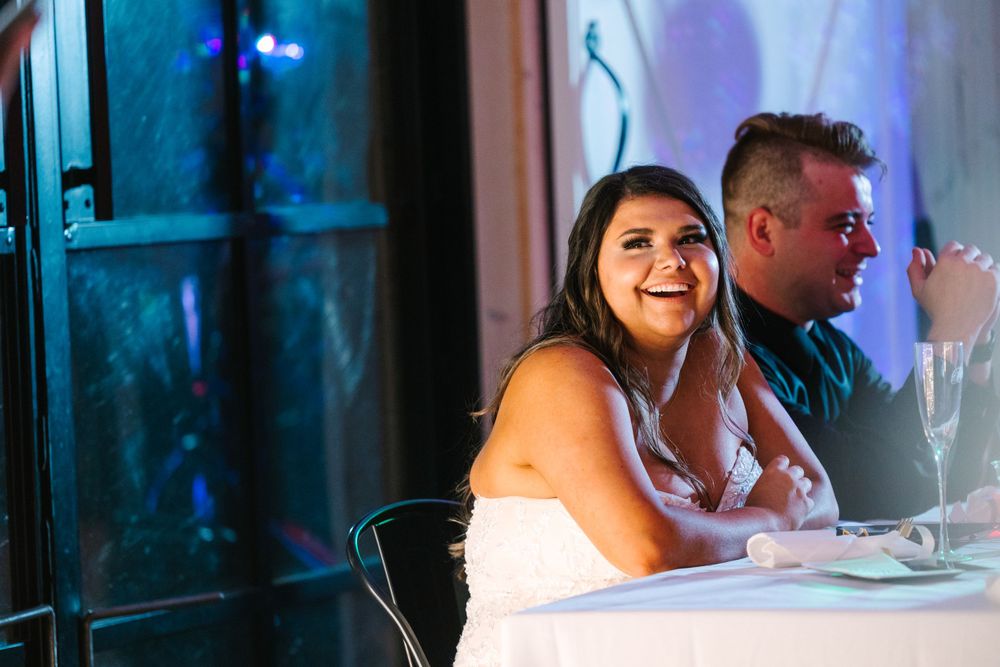 Wedding reception moment captured during dinner speeches with warm lighting and decor.