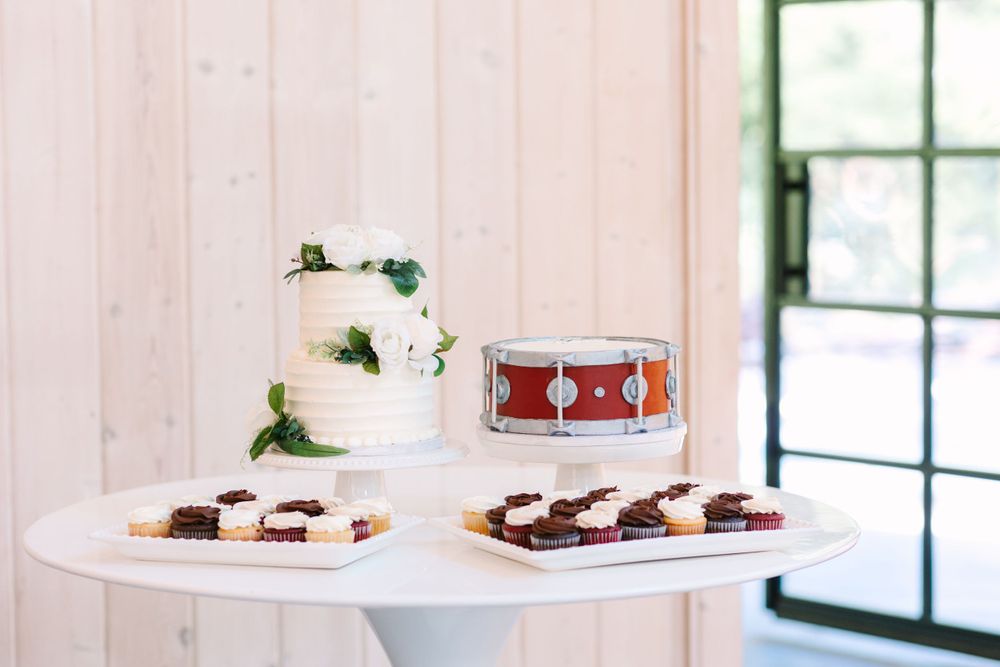 Wedding cake and dessert display table with decorative drum accent piece.