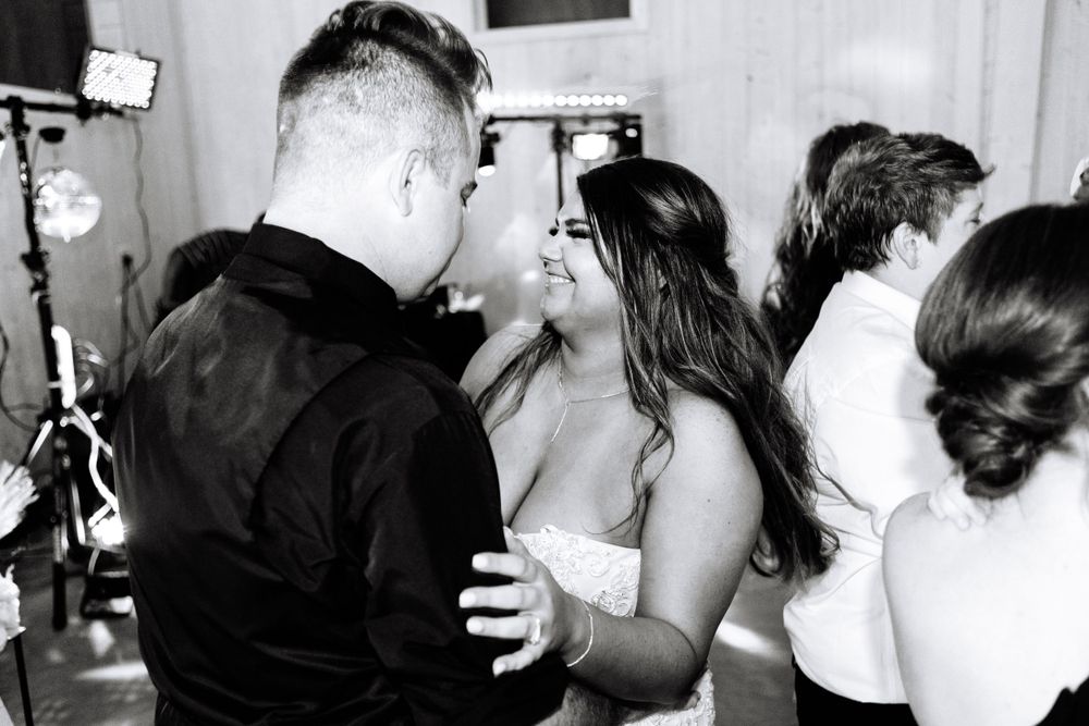 Black and white photo of wedding guests dancing and celebrating on the dance floor.