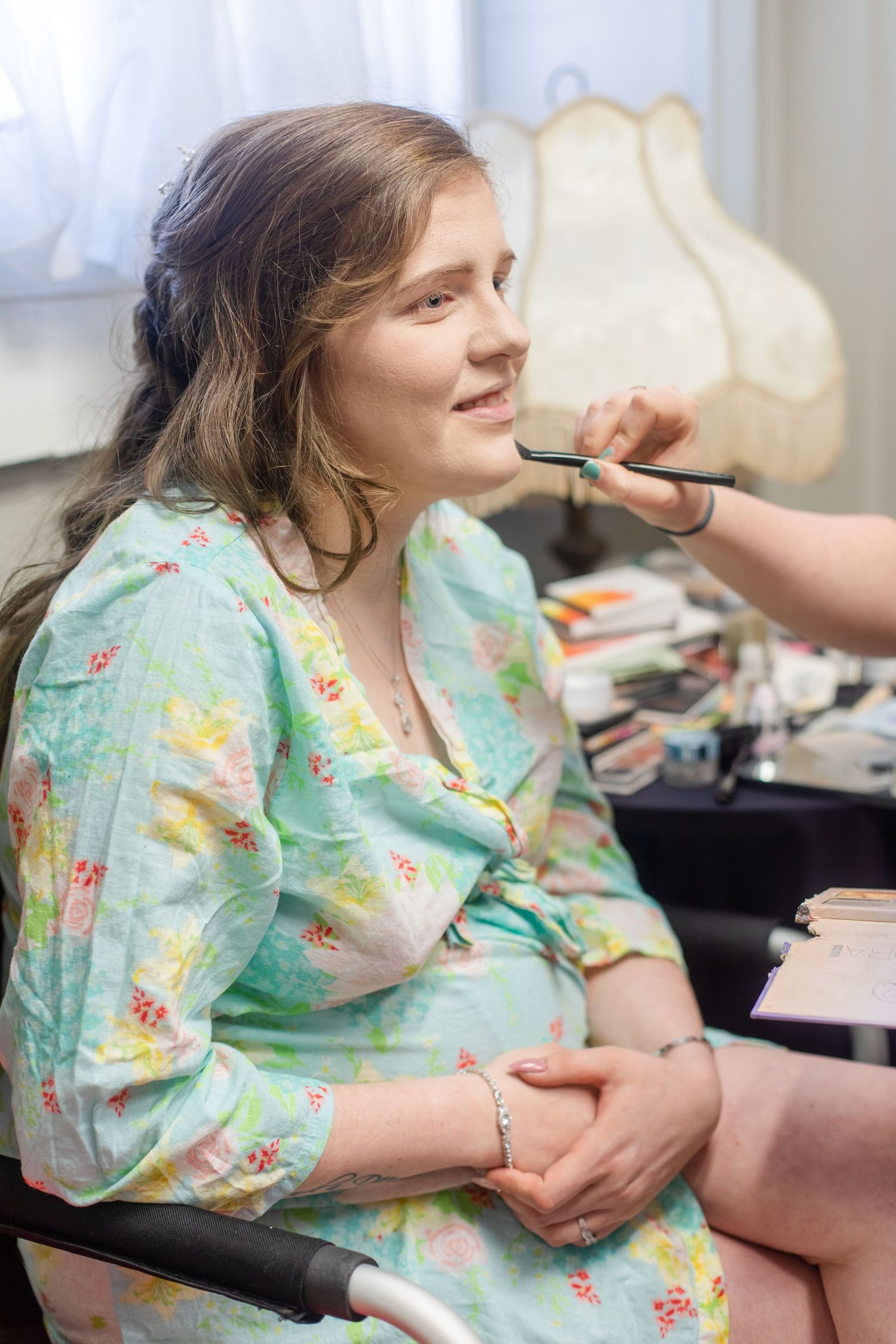Getting ready scene with makeup application in a softly lit room.