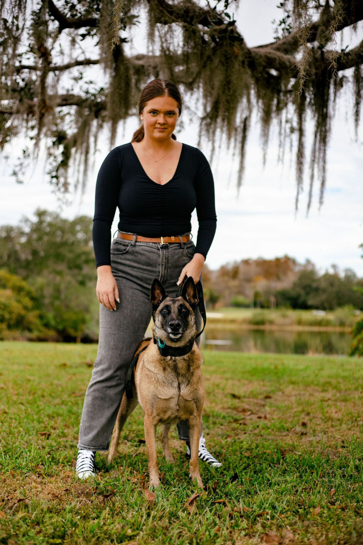 Girl with malinois posing for a photo.