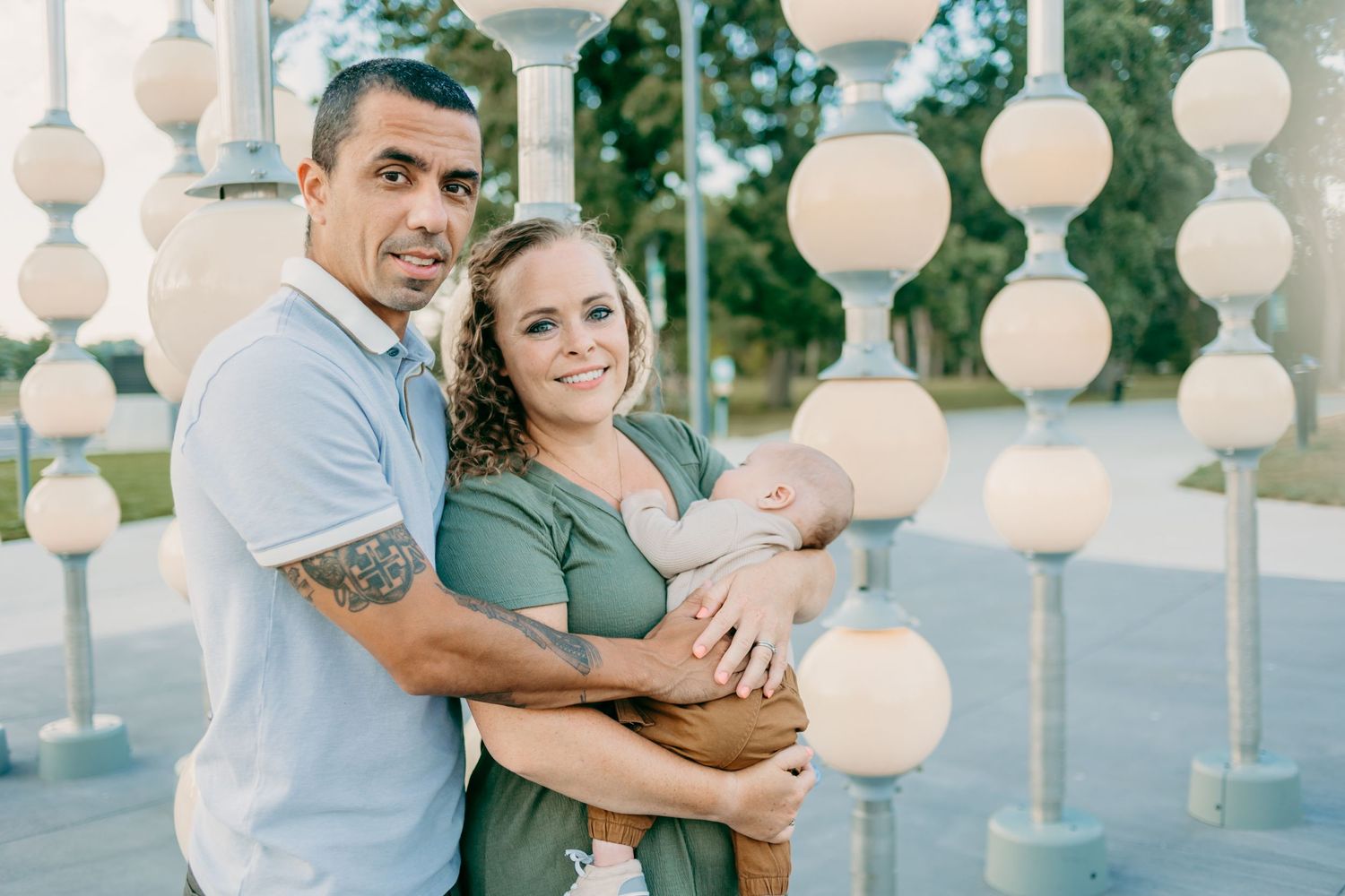 Family posing together under decorative white lanterns outdoors.