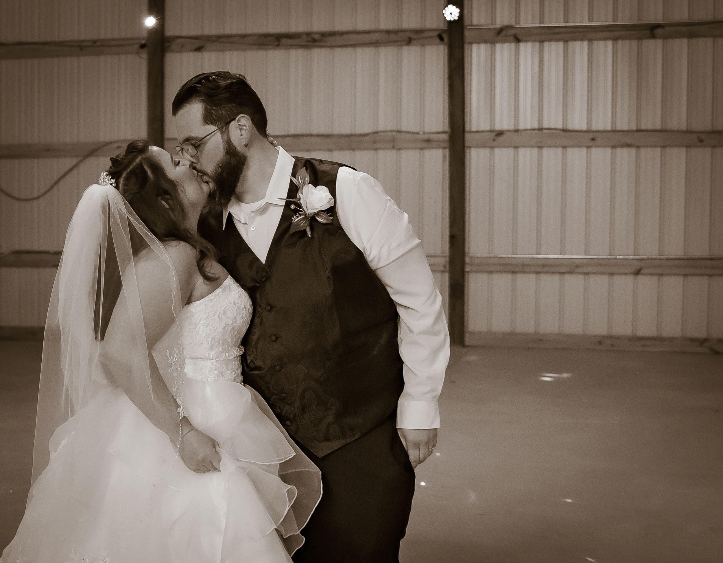 A romantic black and white photo of a couple sharing a kiss.
