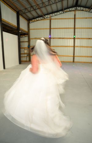Motion-blur photo of a bride spinning in her wedding dress.