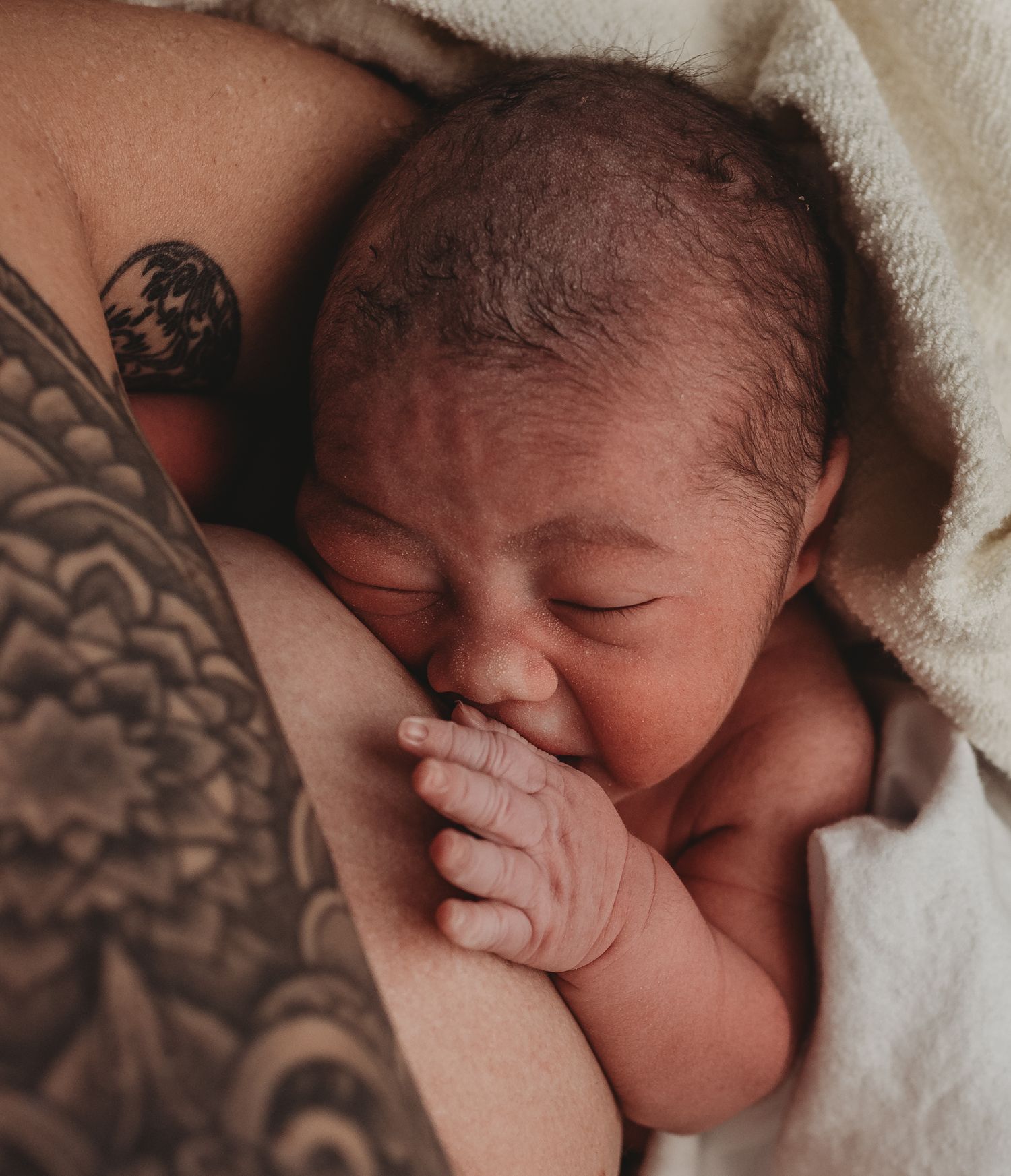 Close-up series of a sleeping newborn baby swaddled in white blankets.
