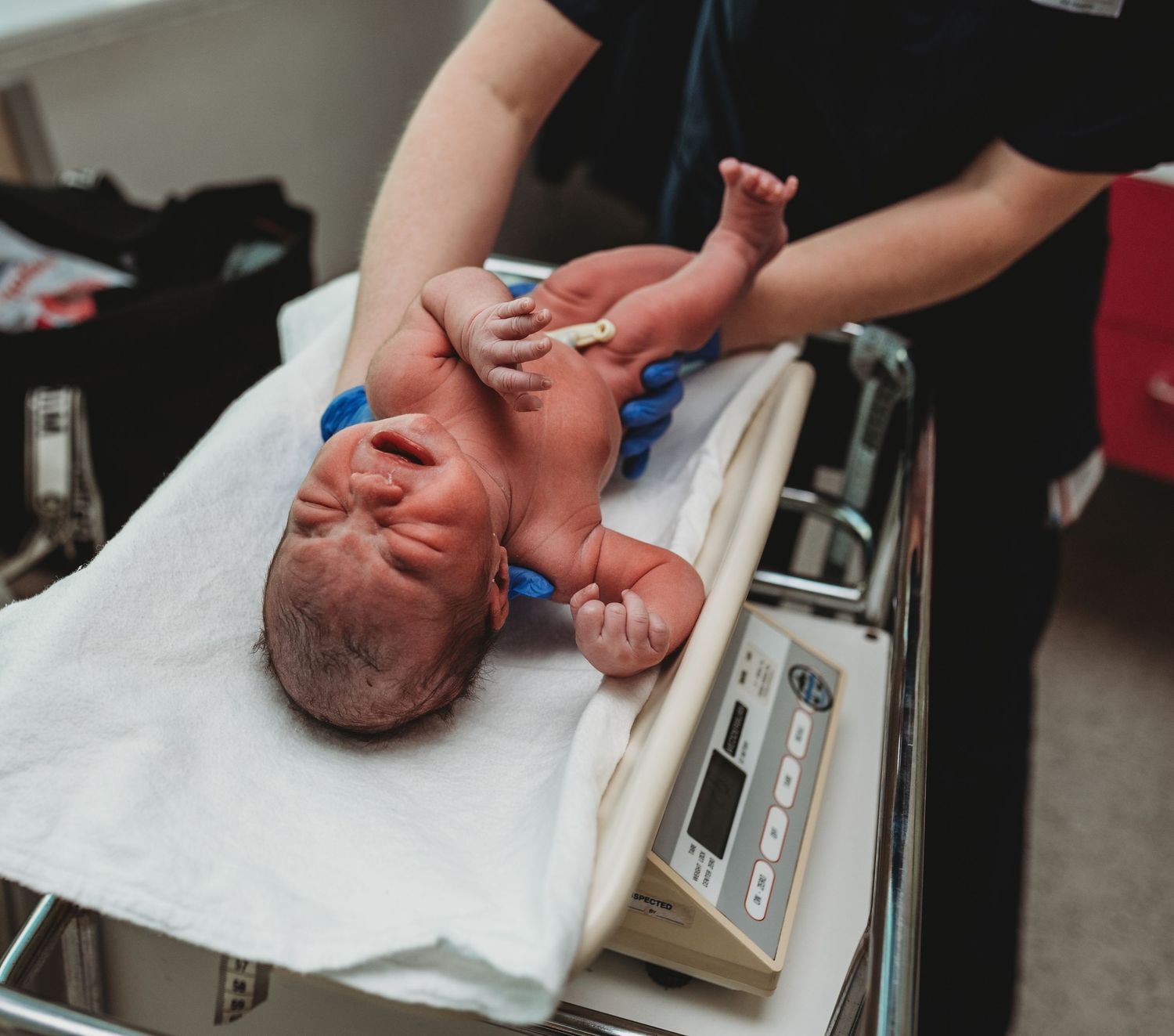 Healthcare worker conducting standard newborn medical examination.