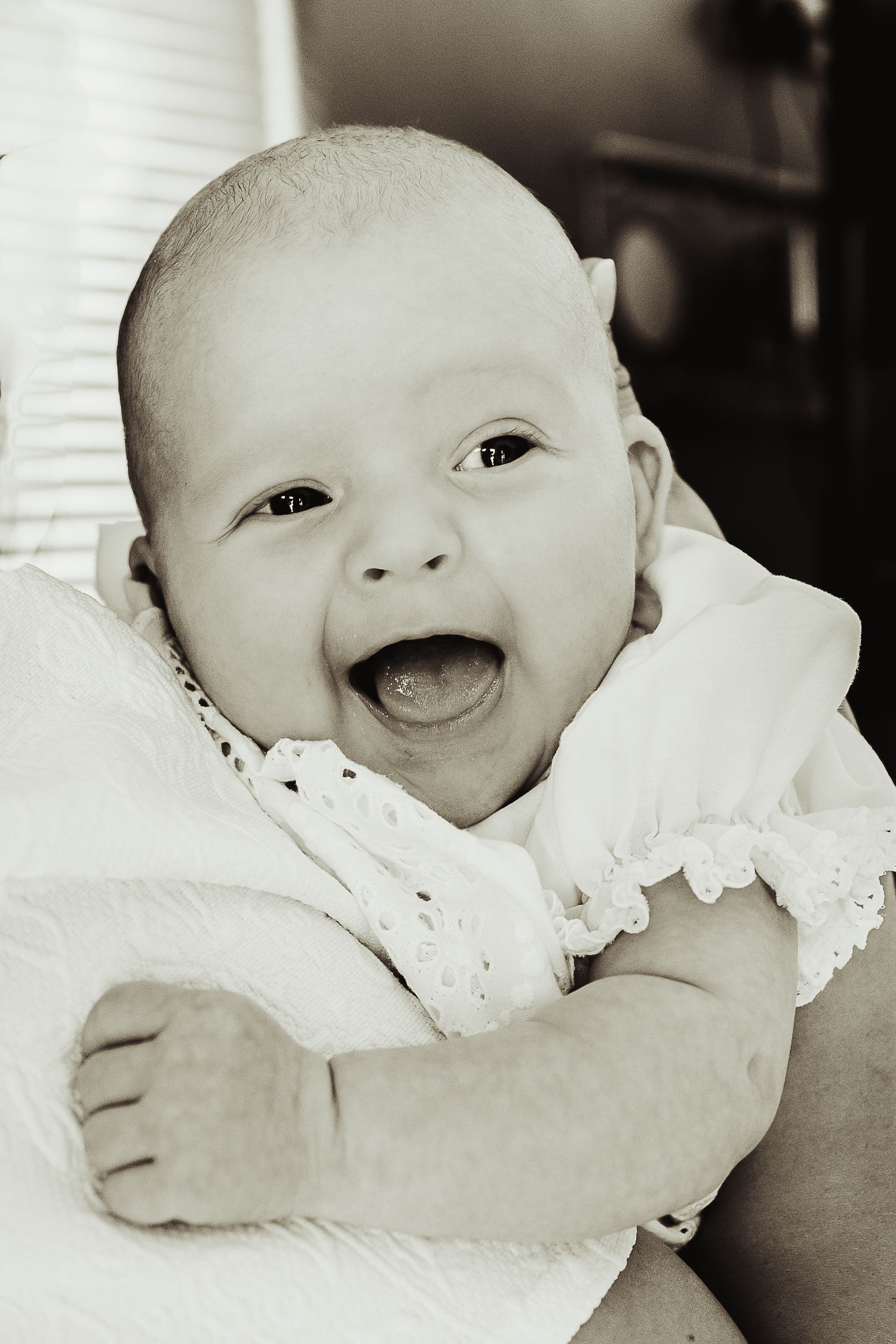 Baby boy smiling over mother's shoulder