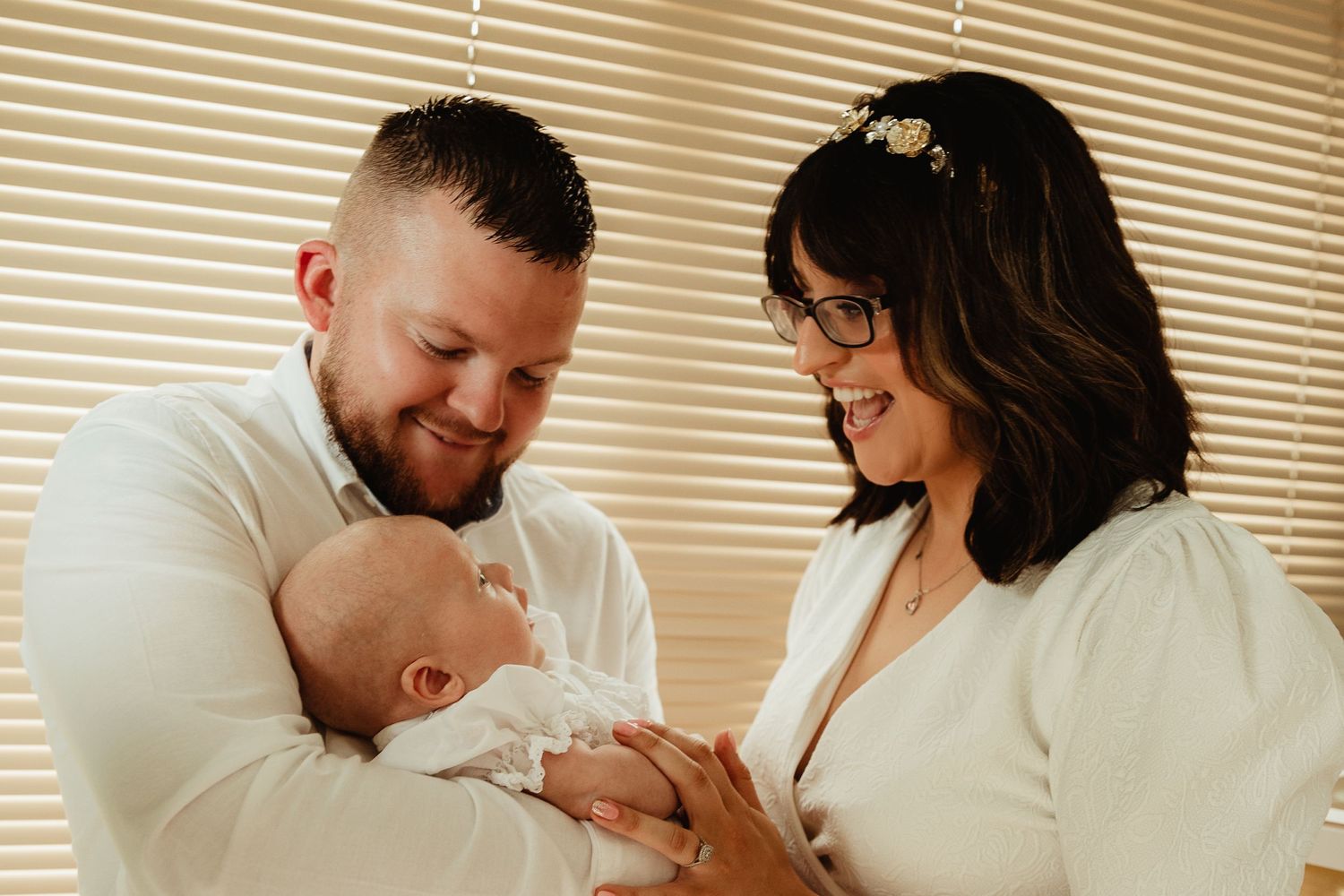 Parents play with son at baptism