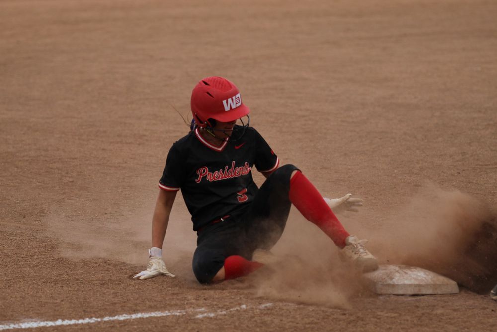 softball player sliding into third