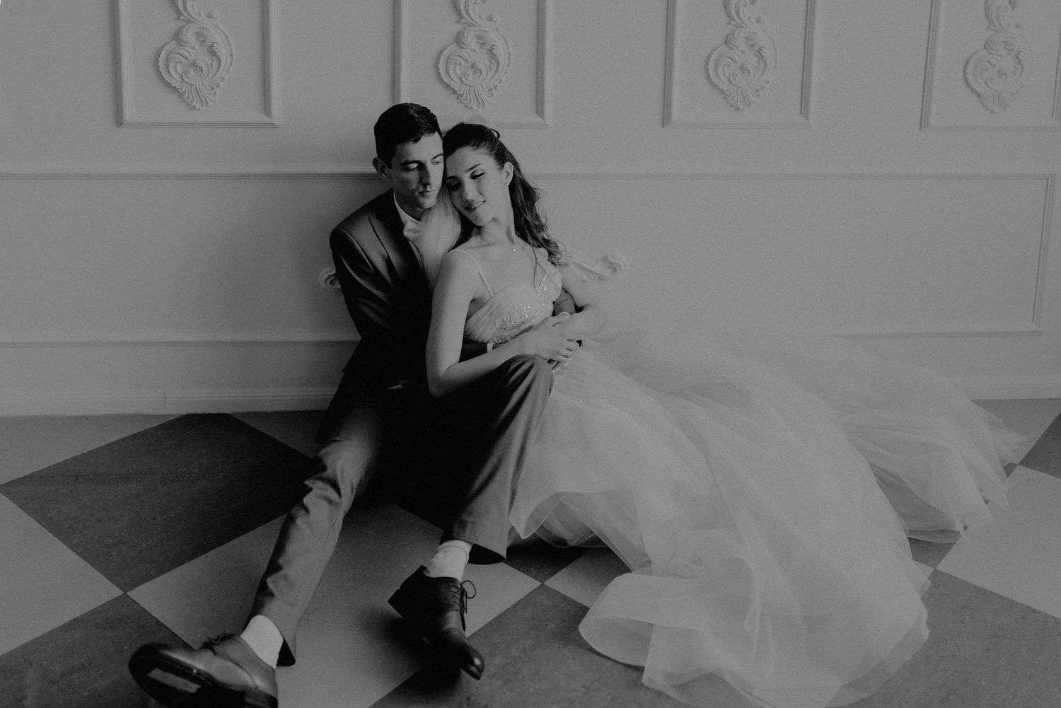 Romantic black and white portrait of a couple in formal wedding attire.