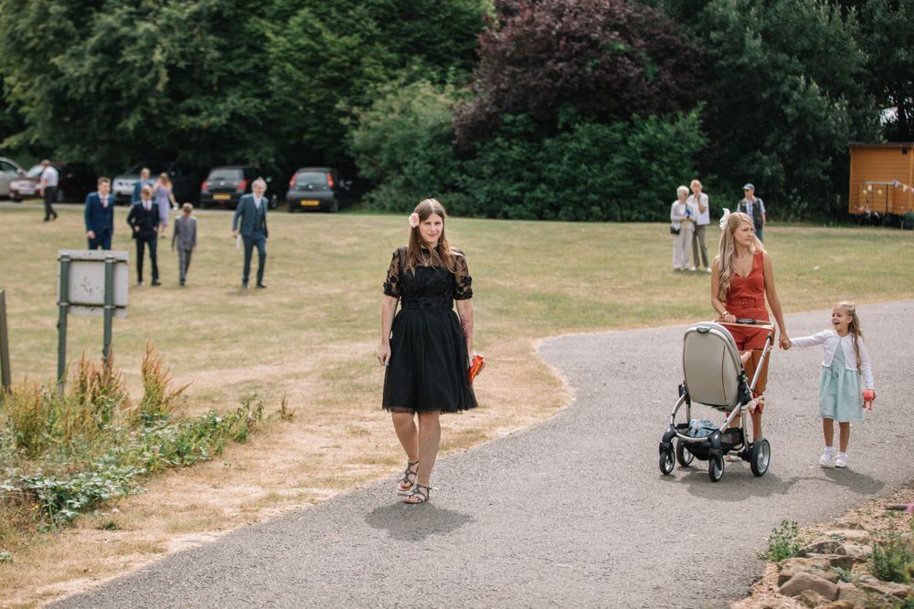 People walking along a curved path in a park on a sunny summer day.