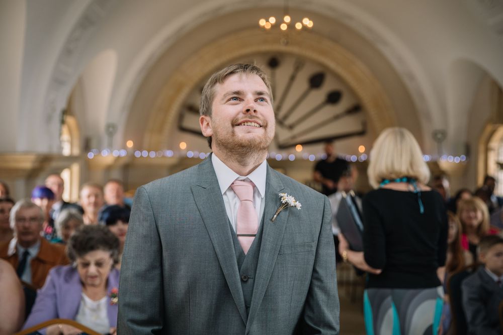 A formal event in an elegant venue with arched ceilings and chandeliers.