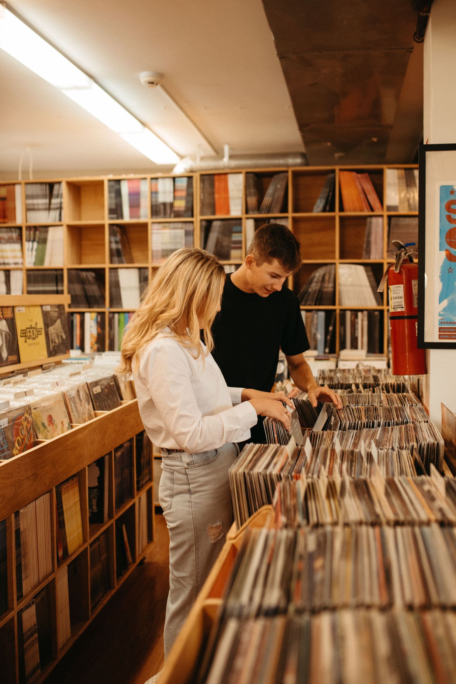 A couple browses through vinyl records together in a record shop.