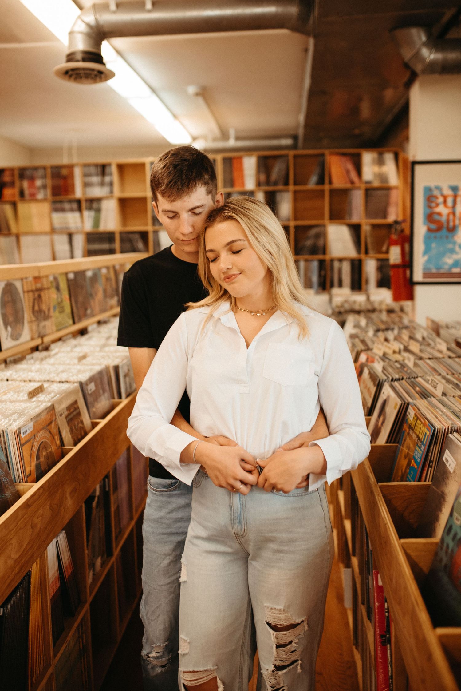 A tender moment between two people browsing records in a vintage music store.