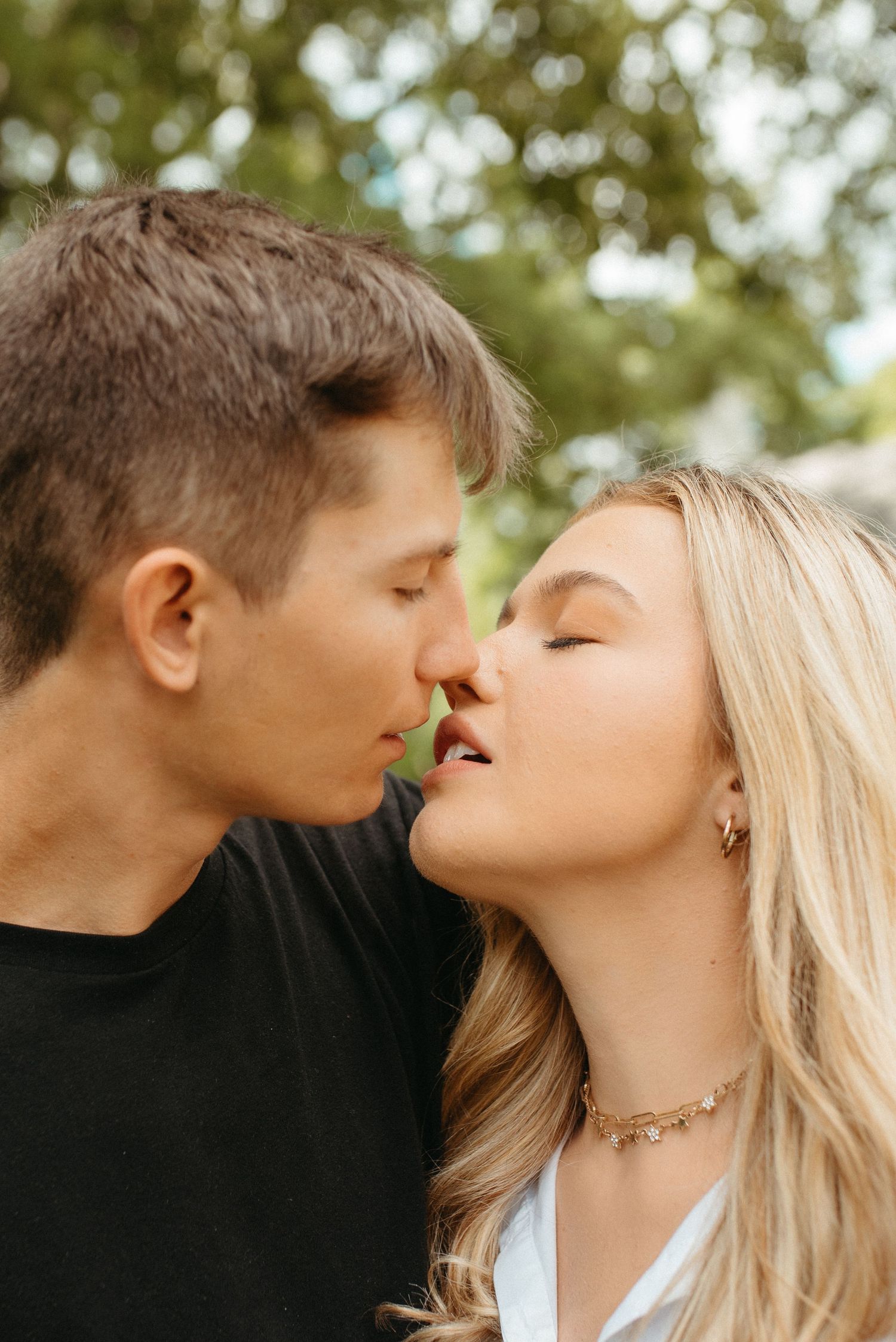 Intimate close-up of couple about to kiss in natural outdoor setting.