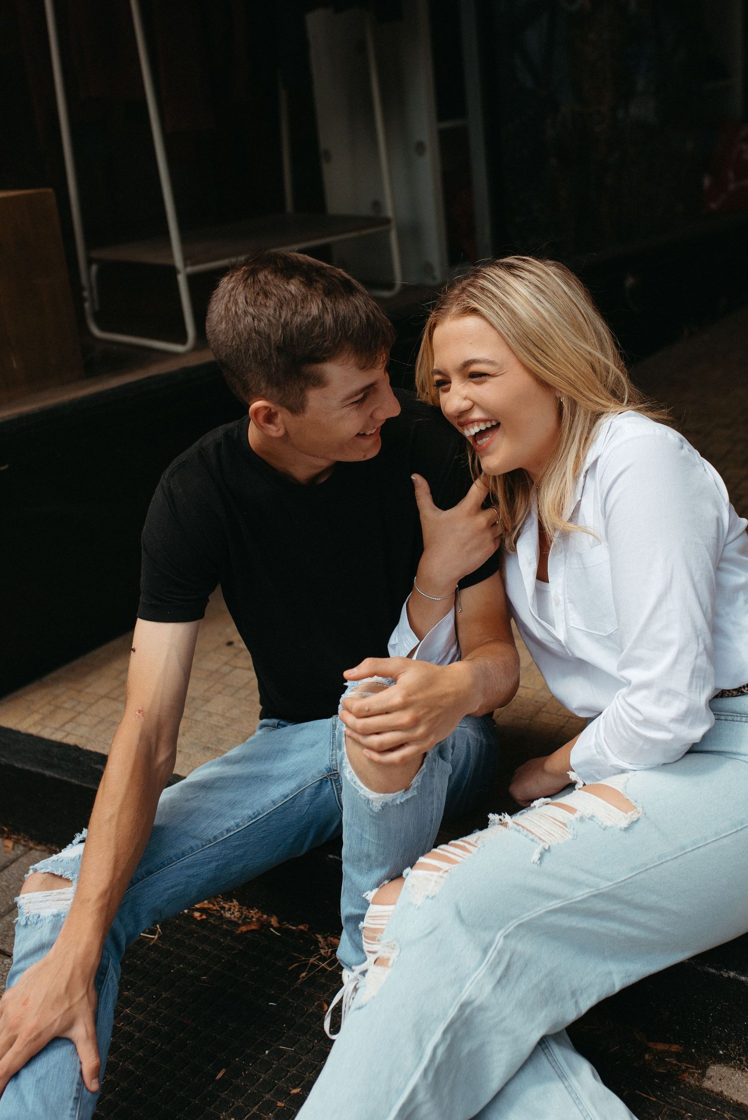 A casual moment shared on wooden steps with natural lighting.