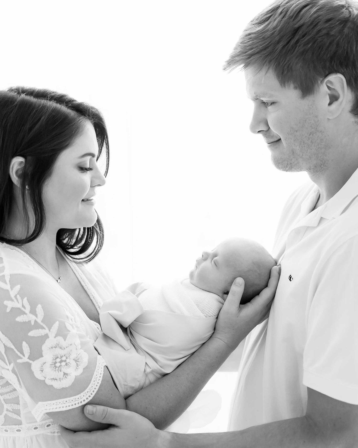 mother and father with newborn baby, simple pure backlighting, baby photography sarasota, englewood birth photograph