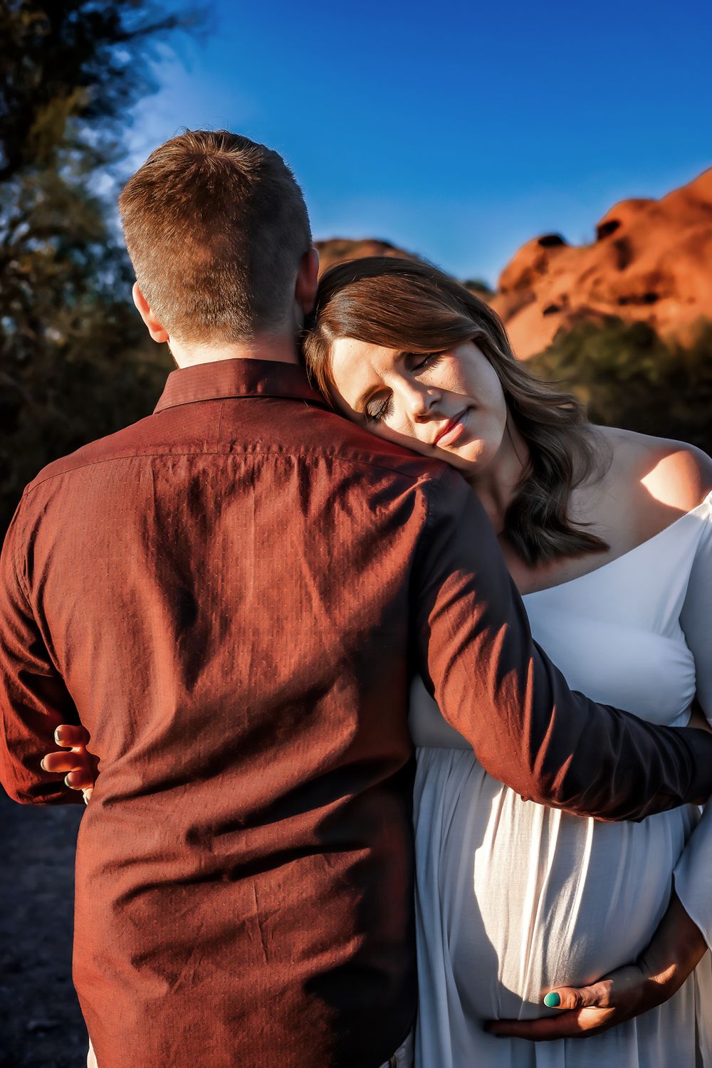An expectant couple sharing a tender moment, with the man supporting his partner's growing belly