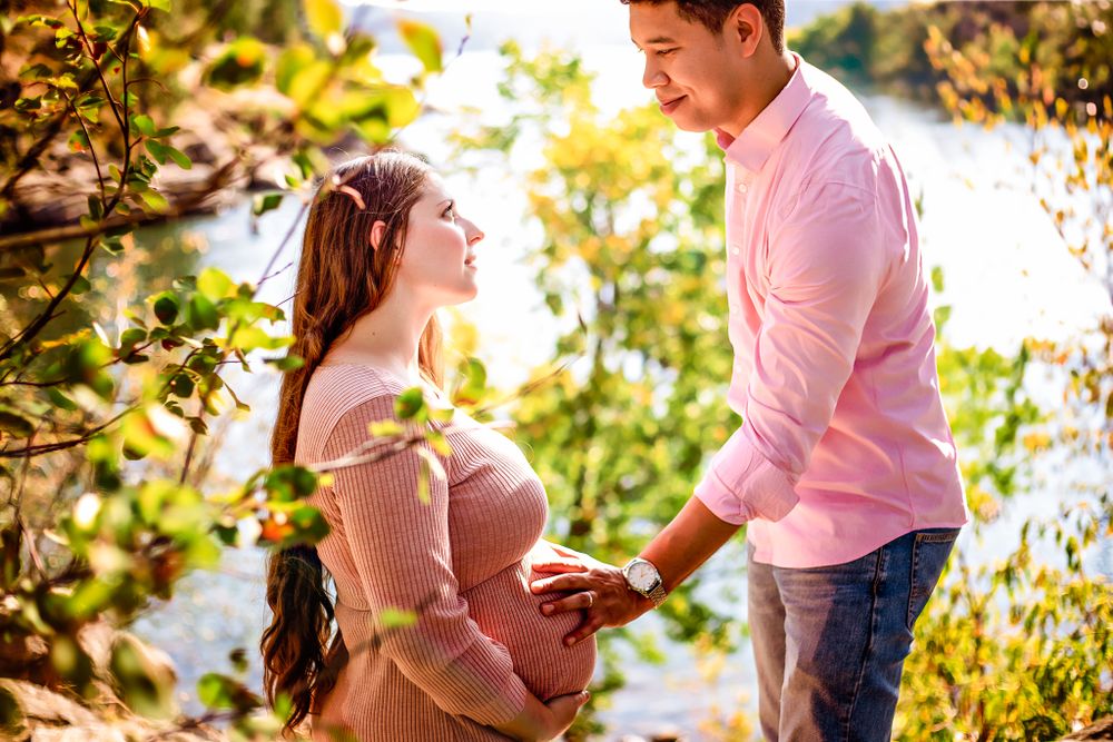 An expectant couple sharing a tender moment, with the man supporting his partner's growing belly