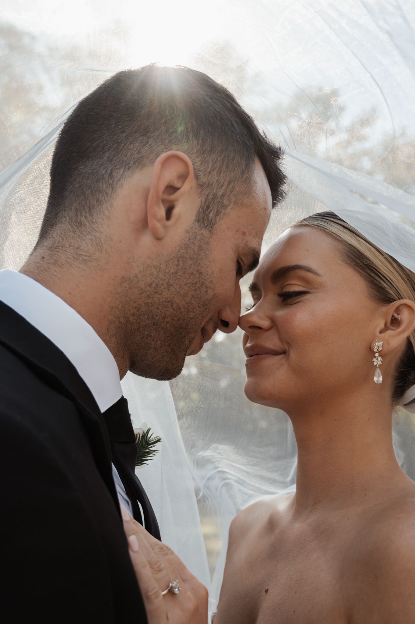 Close-up wedding portraits showing tender moments between newlyweds under a delicate veil.