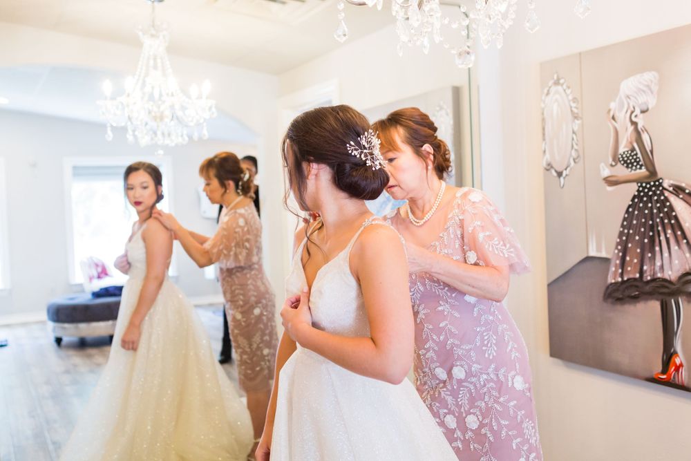 Wedding preparation scene with formal dresses and chandelier lighting.